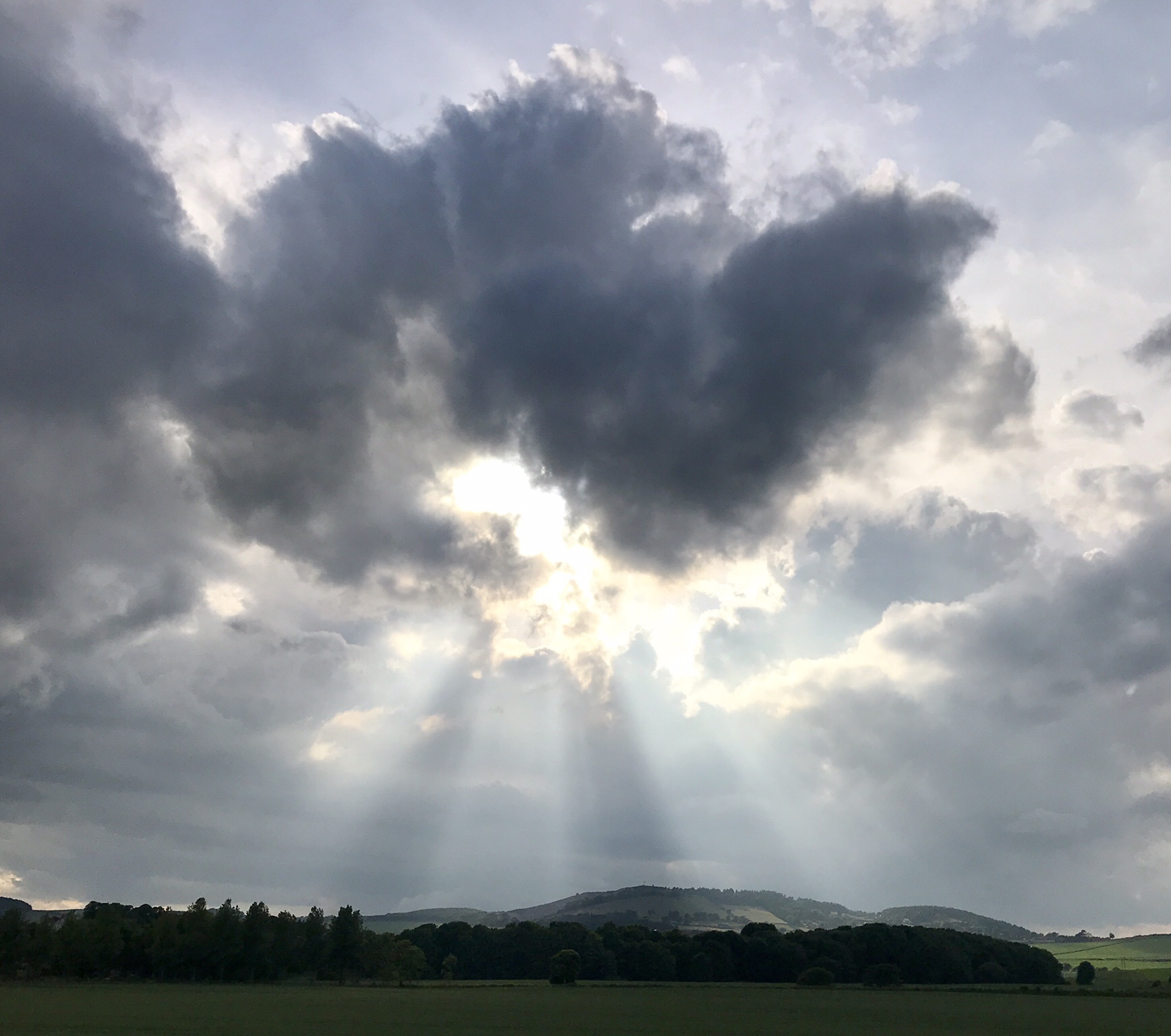Cloudy sky with sun rays breaking through. 